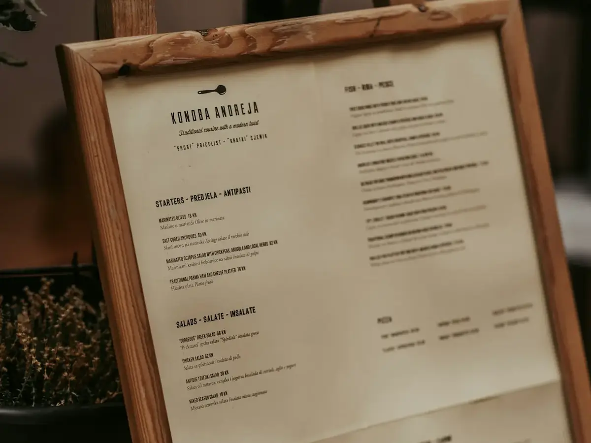 A printed restaurant menu in a wooden frame